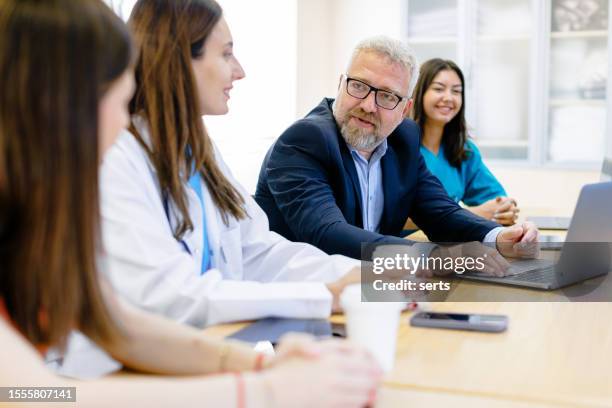 collaborative excellence: group of medical team and business people meeting in hospital and office - nurse manager stock pictures, royalty-free photos & images