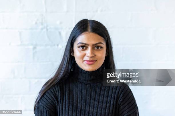 smiling young businesswoman in front of white wall - indian office stock pictures, royalty-free photos & images