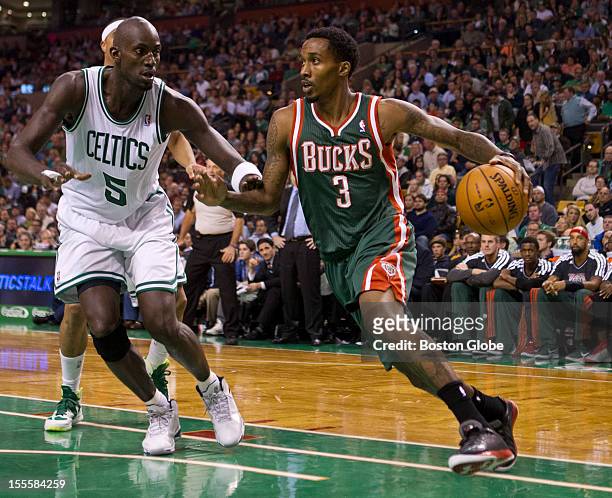 Milwaukee Bucks player Brandon Jennings drives to the basket with defensive pressure from Boston Celtics player Kevin Garnett during second quarter...