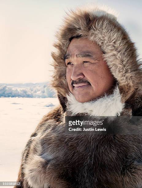 inuit hunter in reindeer fur jacket on ice - grönland stock-fotos und bilder