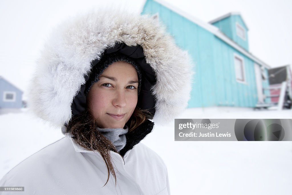 Girl bundled in fur hood in the snowy arctic
