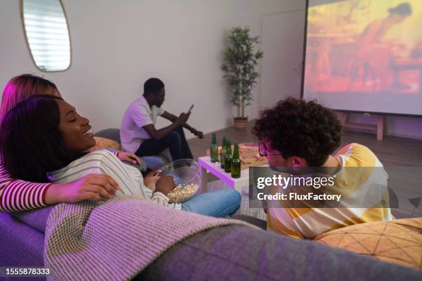multiracial friends watching movie at home on a screen projector - cinema projector stock pictures, royalty-free photos & images