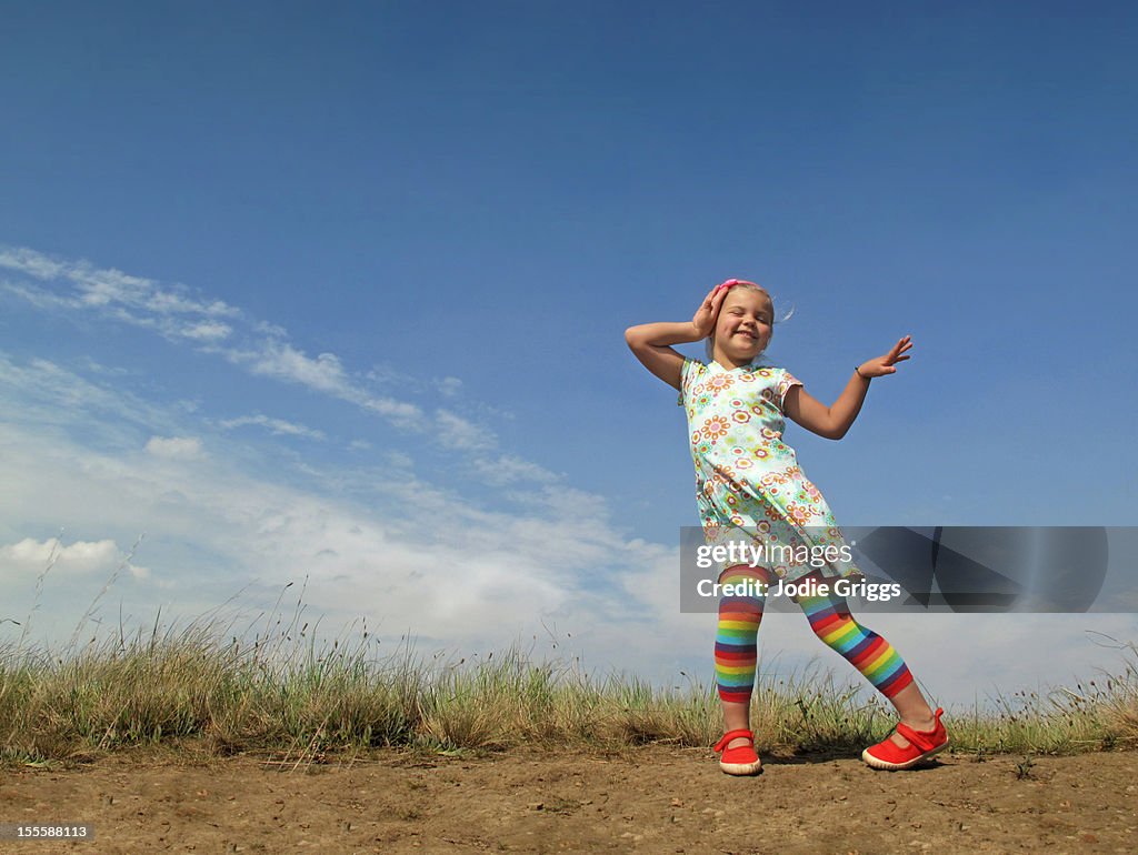 Child with rainbow tights dancing outside