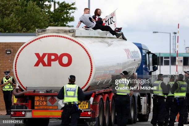 Climate protestors climb onto an oil tanker while demonstrating at Grangemouth INEOS oil refinery on July 19, 2023 in Grangemouth, Scotland....