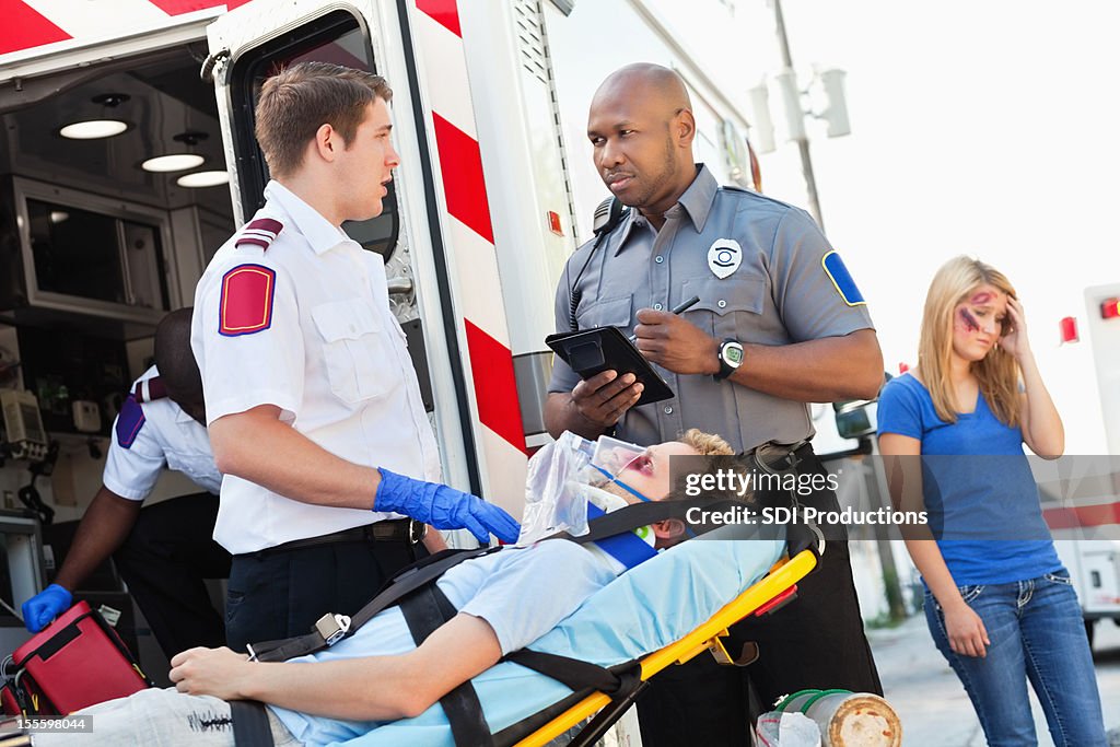 Ambulance medic and police officer discussing accident scene