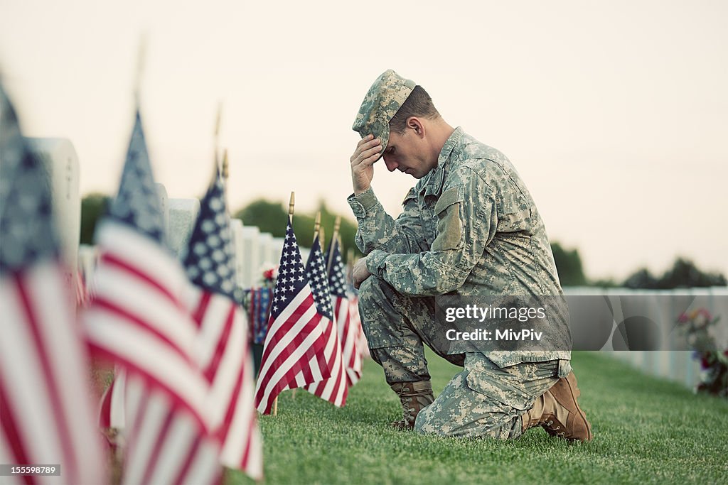 Soldier kneeling at grave