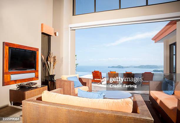 luxury tropical home overlooking to ocean - big screen television stock pictures, royalty-free photos & images