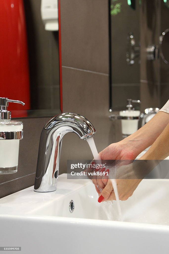 Young woman washing her hands in the bathroom