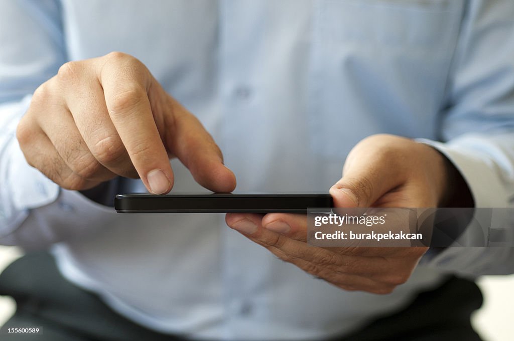 Man hand touching screen on modern mobile smart phone, close-up