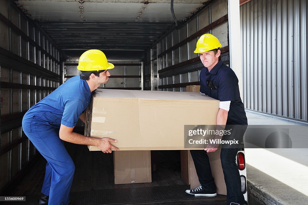 Workers Unloading Heavy Box