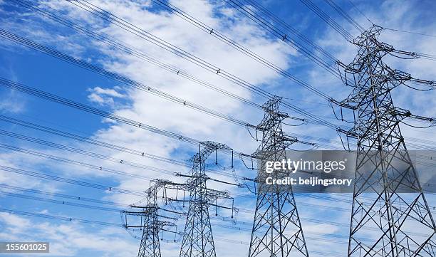 high voltage tower - blue sky - high and low stockfoto's en -beelden