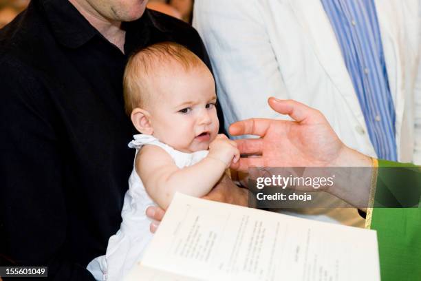 priester ist baptizing kleines baby. - catholic baptism stock-fotos und bilder