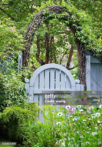 blue garden gate and spring flowers - formal garden gate stock pictures, royalty-free photos & images