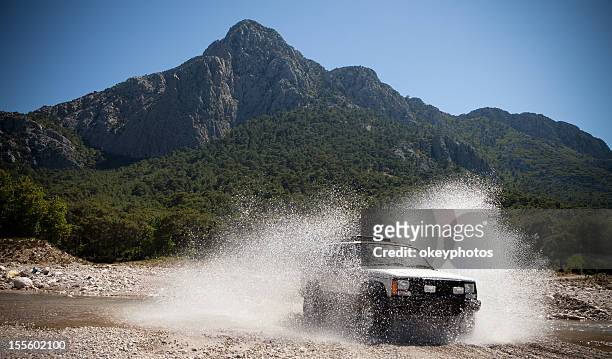 jeep, lancer des cours d'eau de passage - chemin de terre photos et images de collection