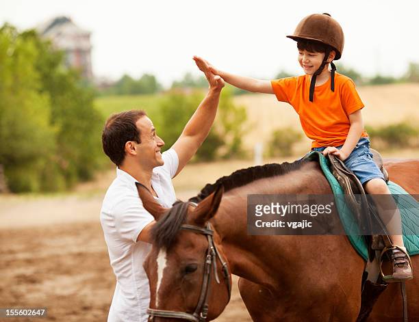 niño montar a caballo al aire libre. - riding hat fotografías e imágenes de stock