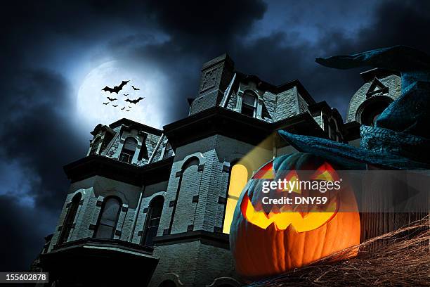 jack o' lantern in front of haunted hose - haunted house stock pictures, royalty-free photos & images