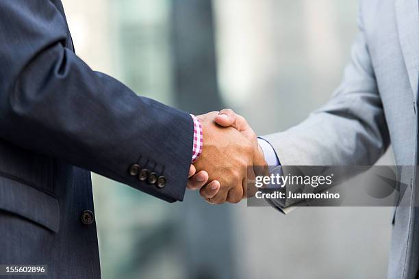 two businessmen shaking hands - handtag bildbanksfoton och bilder