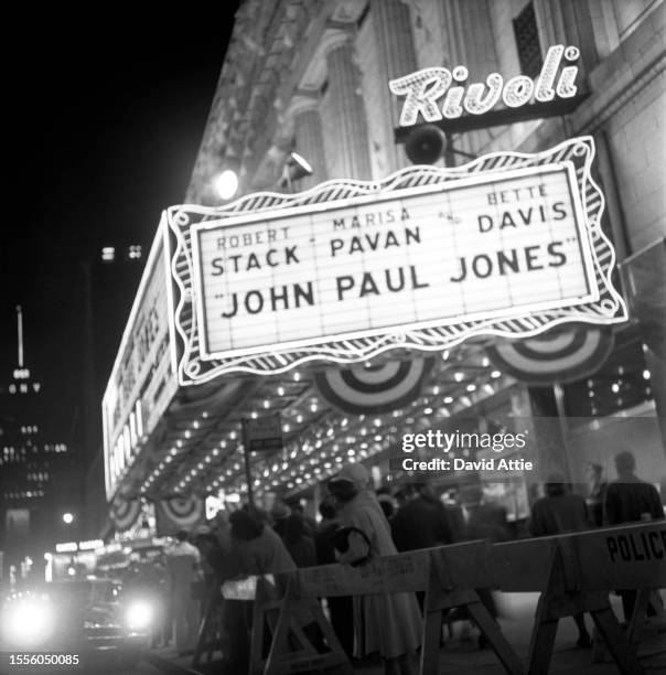 Crowds wait as limousines arrive and police idle outside the Rivoli Theater at 1620 Broadway for the world premiere of the movie "John Paul Jones,"...