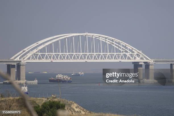 Cargo ships and car ferries cross the Kerch Strait as the Crimea bridge is seen behind as Russia-Ukraine war continues in Crimea on July 25, 2023....