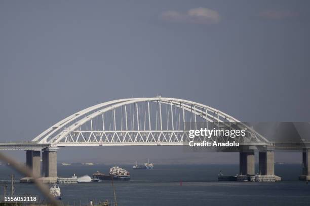 Cargo ships and car ferries cross the Kerch Strait as the Crimea bridge is seen behind as Russia-Ukraine war continues in Crimea on July 25, 2023....