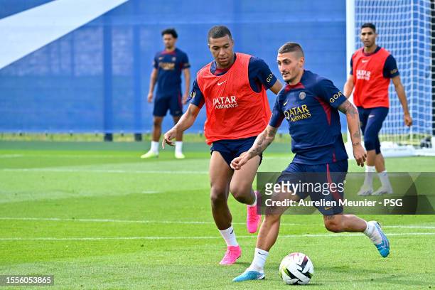 Marco Verratti and Kylian Mbappe fight for possession during a Paris Saint-Germain training session at PSG Campus on July 19, 2023 in Poissy, France.