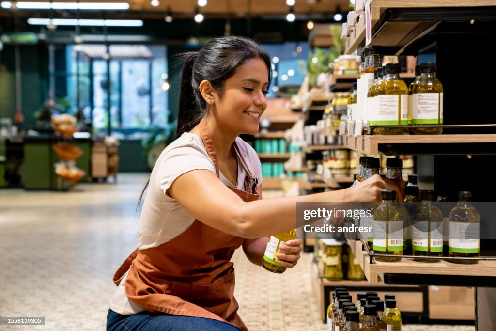 Einzelhandelskauffrau, die im Supermarkt arbeitet und die Regale umstellt