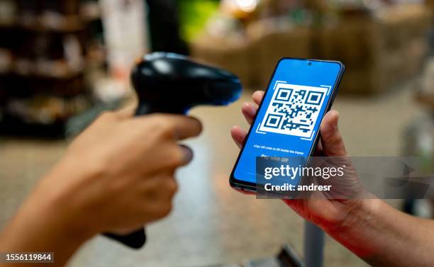 cajero escaneando un código qr en el supermercado - tarjeta de lealtad fotografías e imágenes de stock