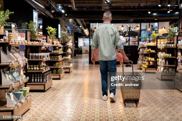 mann im supermarkt einkaufen im supermarkt - supermarkt gang stock-fotos und bilder