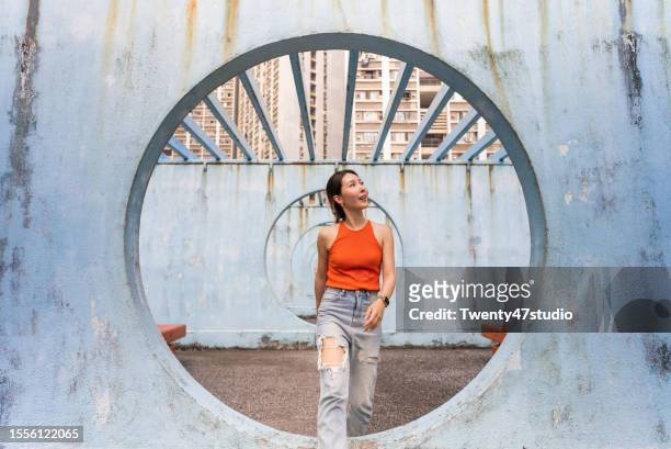 a woman walking inside a circle shaped structure in lok wah estate in hong kong - color enhanced stock pictures, royalty-free photos & images