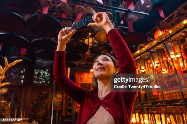 asian woman traveling at man mo temple in hong kong - smartphones dangling stock pictures, royalty-free photos & images