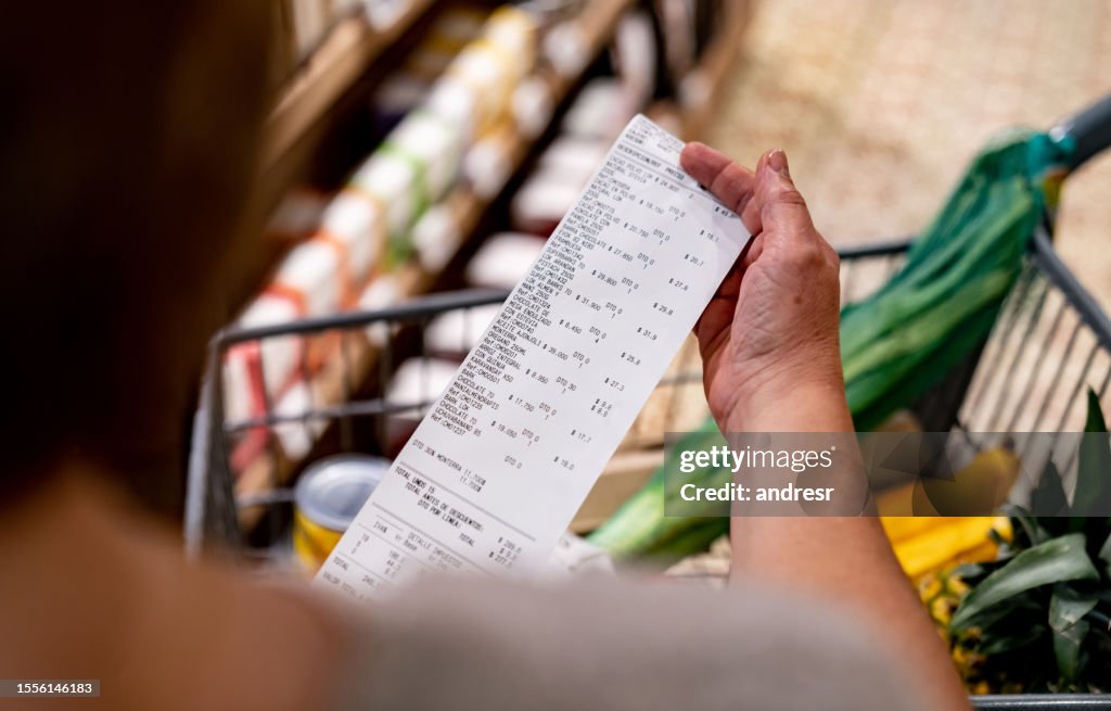 Mujer mirando un recibo después de comprar en el supermercado
