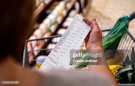 Woman looking at a receipt after shopping at the supermarket Woman looking at a receipt after shopping at the supermarket