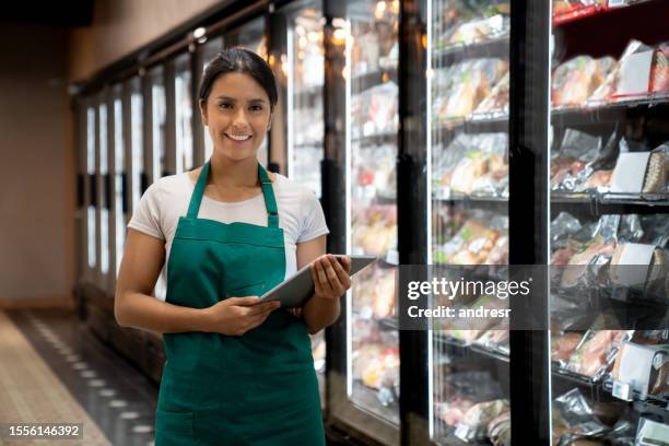 porträt eines einzelhandelsangestellten, der in einem supermarkt arbeitet - straßenverkäufer stock-fotos und bilder