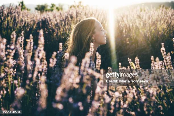 photo of a smiling young woman in lavender field; enjoying the beautiful and peaceful weekend getaway. - lavendel stock-fotos und bilder