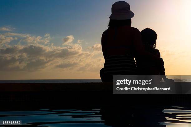 mother and daughter watching sunset - vietnamese ethnicity stock pictures, royalty-free photos & images