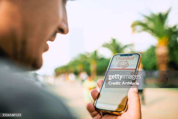 hombre hablando con un chatbot con comandos de voz usando un teléfono inteligente. asistente de servicio robot, inteligencia artificial moderna, innovación futurista y concepto de tecnología. - marie say fotografías e imágenes de stock