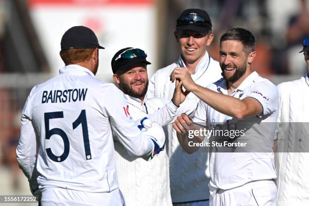 Chris Woakes of England celebrates the wicket of Alex Carey of Australia with teammates Ben Duckett and Jonny Bairstow during Day One of the LV=...