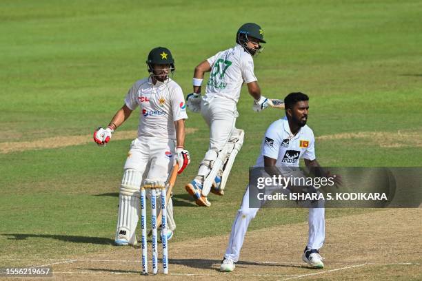 Pakistan's Abdullah Shafique and Agha Salman run between wickets as Sri Lanka's Asitha Fernando watches during the third day of the second and final...