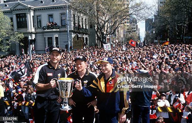Stewart Loewe and Nathan Burke Co-Captains of St Kilda hold the Premiership Cup with Mark Bickley Captain of Adelaide, during the Grand Final Parade...