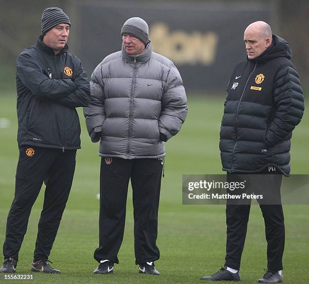 Manager Sir Alex Ferguson of Manchester United speaks to First Team Coach Rene Meulensteen and Assistant Manager Mike Phelan during a first team...