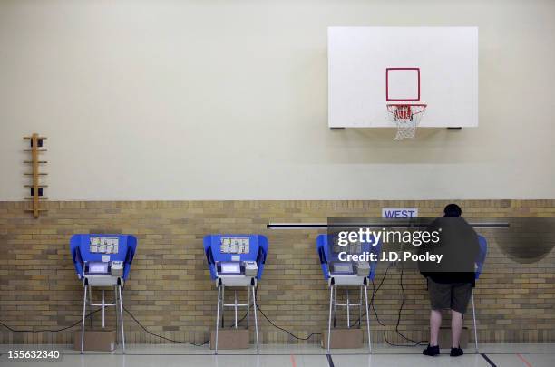 Man casts his ballot using an electronic voting machine November 6, 2012 at an elementary school in Bowling Green, Ohio. Voting is underway in the US...