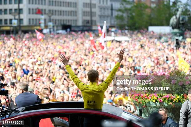 Denmark's Jonas Vingegaard rider of the Jumbo-Visma team and winner of the 2023 edition of the Tour de France, raises his arms in front of a cheering...