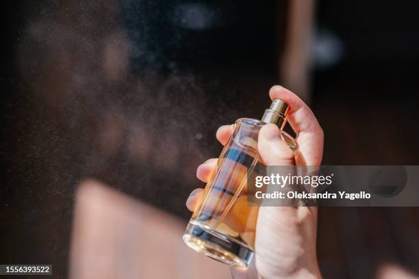 unrecognizable bottle of perfume in hand - profumato foto e immagini stock