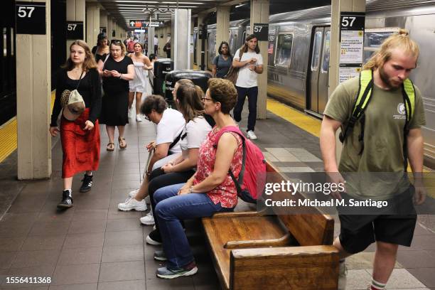 People walk along the subway platform at the 57th Street subway station on July 19, 2023 in New York City. The MTA board announced that subway and...