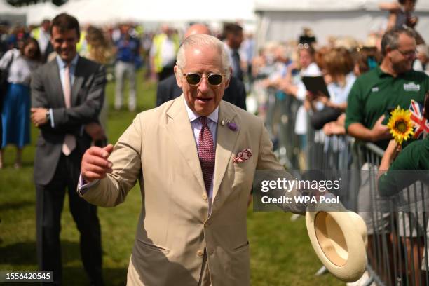 King Charles III reacts as he meets members of the public at the Sandringham Flower Show at Sandringham House on July 26, 2023 in King's Lynn,...