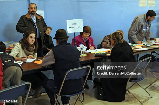 People are helped with same day registration as voters cast their ballots at the Bishop Leo O'Neil Youth Center on November 6, 2012 in Manchester,...
