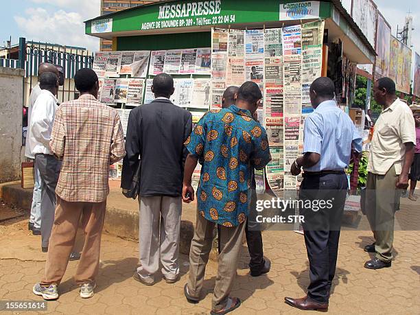 People look at newspapers featuring portraits of Cameroon's President at a newsstand in Yaounde on November 6, 2012. Cameroonian President Paul Biya...