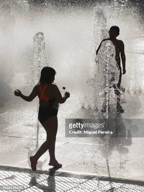 Children play on water jets at a public square on a very hot afternoon on July 19, 2023 in Madrid, Spain. An area of high pressure, named Cerberus...
