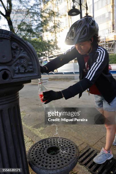 Food delivery rider gets water from a public fountain on a very hot afternoon on July 19, 2023 in Madrid, Spain. An area of high pressure, named...