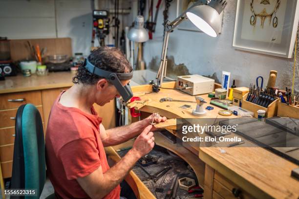 jeweler artisan at his workshop - golden goggles 個照片及圖片檔